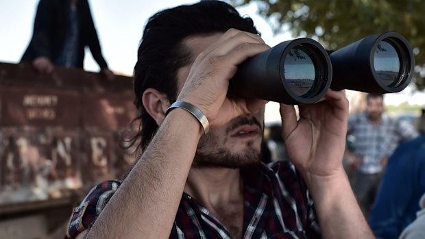 A Kurdish man watches fighting in Kobane.