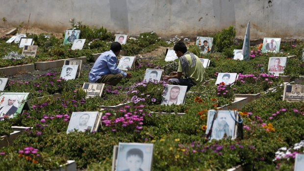 Shiite rebels, known as Houthis, pray at portrait adorned graves of Houthi fighters in Sanaa last week.