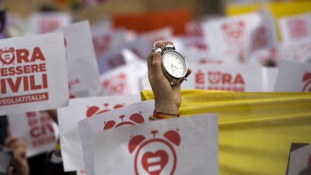 An activist holds up an alarm clock during a demonstration in Rome, symbolically asking Italian MPs to wake up and approve a law in favour of rights for gay couples.  