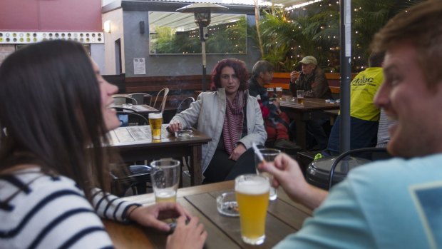 Lee Sultana, smokes a cigarette in the courtyard of the Carlisle Hotel, Newtown.