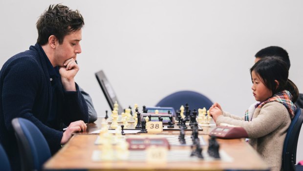 Labor MLA Michael Pettersson takes on Garran primary school student Hannah Ni in the ANU Open Chess Tournament on Sunday.