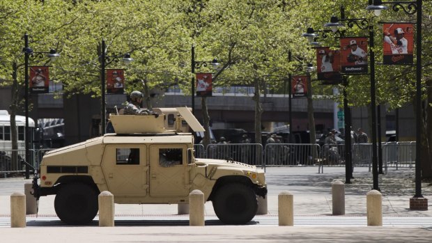 A National Guard vehicle passes outside Oriole Park at Camden Yards before a spectator-free baseball game.