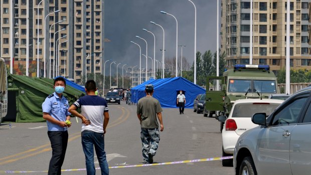 Police draw a fire line a couple of kilometres away from the blast site. 