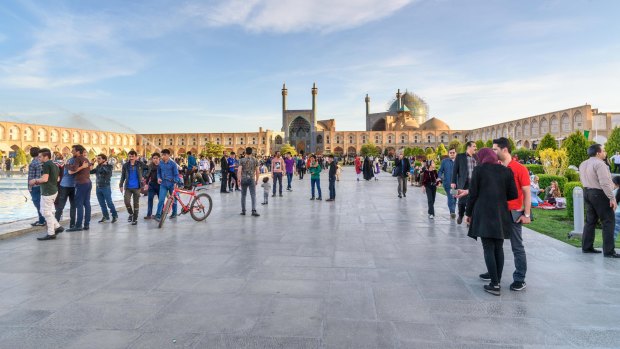 People socialise at Naghsh-e Jahan Square, with  Imam Mosque in the background.