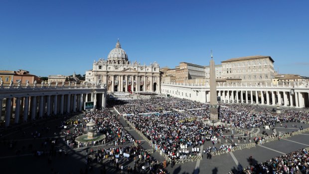 People gather in St Peter's Square to attend the Canonisation Mass.