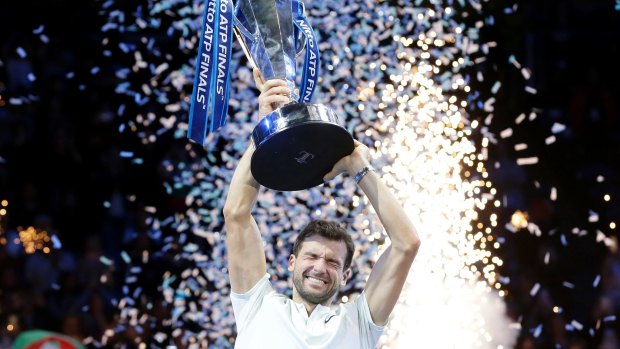 Grigor Dimitrov of Bulgaria lifts the trophy after defeating David Goffin of Belgium in London.