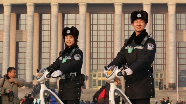 Security guards patrol Tiananmen Square during the National People's Congress. Beijing knows that carefully choreographed set pieces for traditional media may fall flat with China's youth.