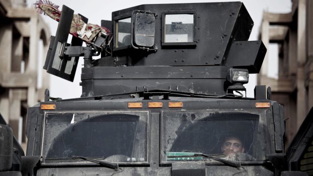 A soldier from Iraq's elite counter-terrorism forces monitors radio traffic from an armoured vehicle as special forces enter Shuhada.
