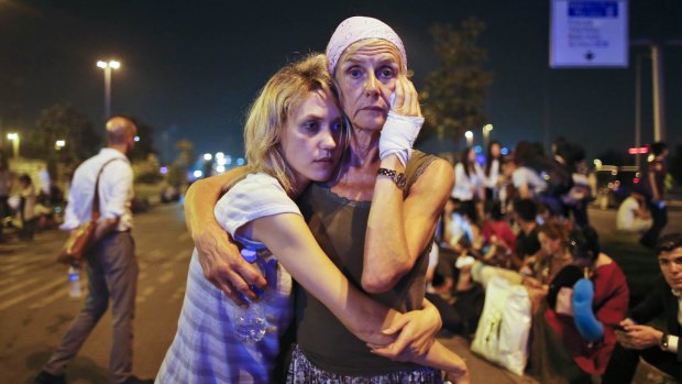 Passengers embrace as they wait outside Istanbul's Ataturk airport, following their evacuation after the attack.