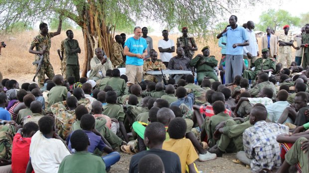 Shaun Collins (centre), a UNICEF child protection specialist, addresses some of the 250 children released from the South Sudan Democratic Army Cobra Faction armed group, in the remote village of Lekuangole in March.

