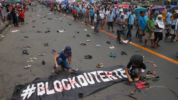 Protesters scatter pairs of slippers and shoes to symbolise victims of President Rodrigo Duterte's "war on drugs".