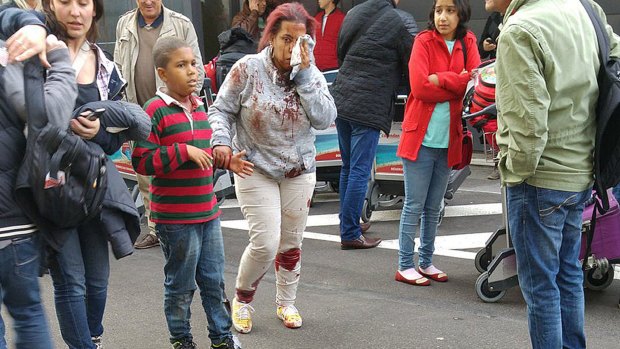 An injured woman leaves the scene at Brussels airport, after explosions rocked the facility on Tuesday.