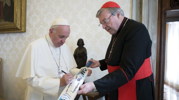 Cardinal George Pell presents a cricket bat to Pope Francis after a friendly cricket match at the Vatican in October 2015.