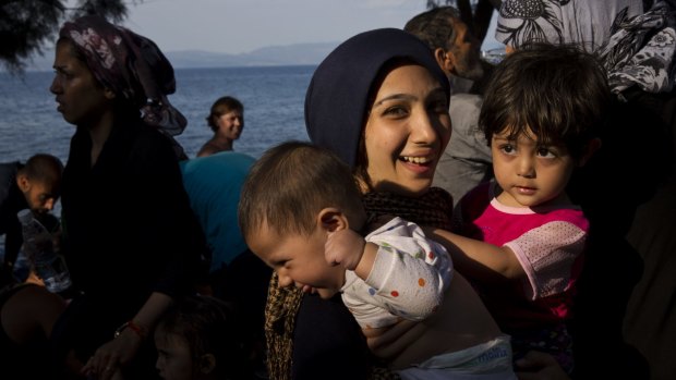 A migrant holds her children after arriving at Lesbos.