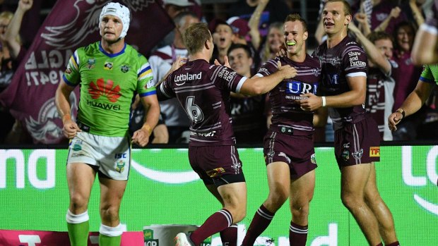 Daly Cherry-Evans (second right) of the Sea Eagles celebrates with teammates after scoring a try.