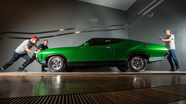 Art installers (l-r) Tony Mahony, Toby Pola and James Taylor install a green XA Ford Falcon muscle car for the <i>Shifting Gears</i> exhibition at the National Gallery of Victoria.