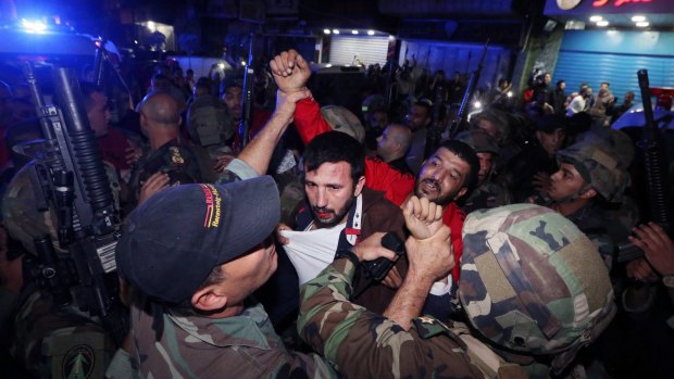 Lebanese soldiers arrest a suspected attacker near the scene of a twin suicide attack in Beirut.