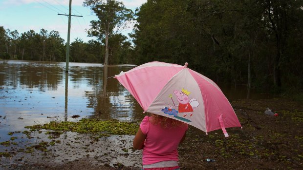 Chloe Nelson, 5, looks out at flood water near her home outside Jimboomba.