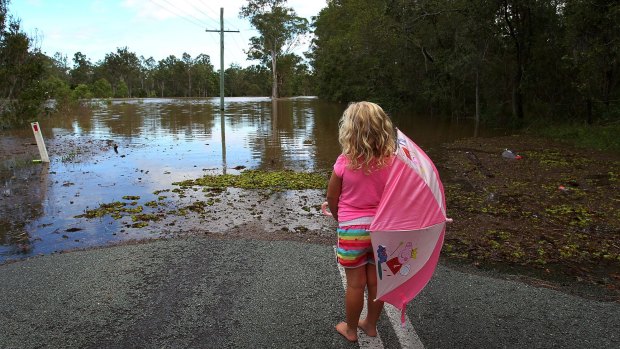 Chloe Nelson, 5, looks out at flood water near her home outside Jimboomba.