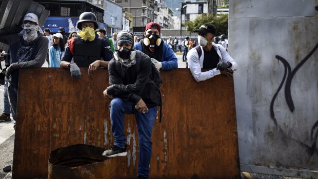 Demonstrators stand at a barricade in Caracas.