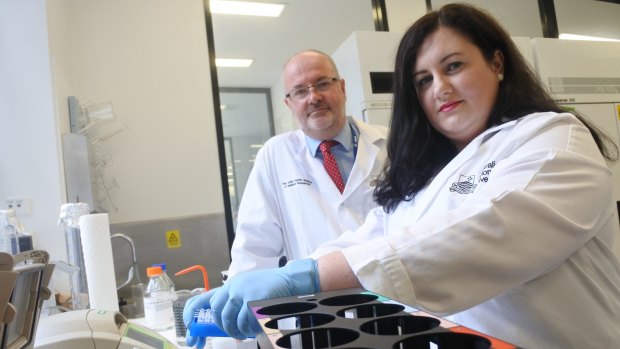 Manager of the Target and Drug Discovery Platform Dr Amee George and ACT Centenary Chair of Cancer Research Professor Ross Hannan in the lab that houses the new robotic system that fast-tracks the development of new drugs to fight cancer and other diseases.