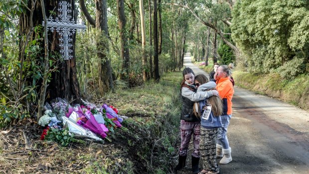 Friends comfort each other at the scene of the fatal crash.