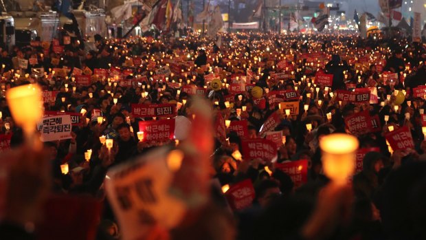 South Korean protesters hold up candles during the rally.