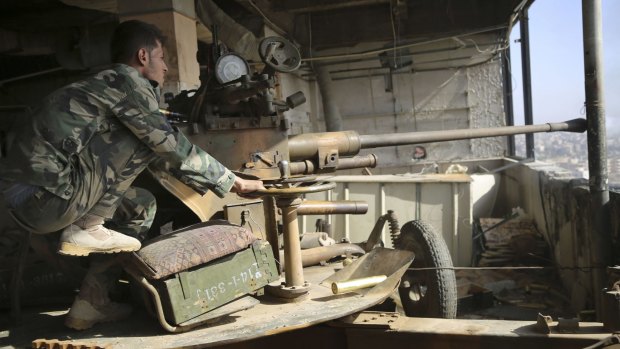 Syrian Army soldier operates a cannon during fighting in Syria.