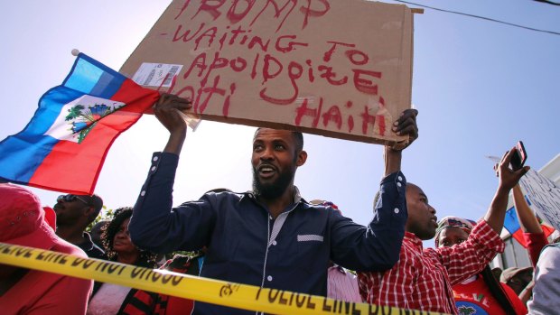 A protester demands an apology from Trump for racist remarks he's reported to have made.