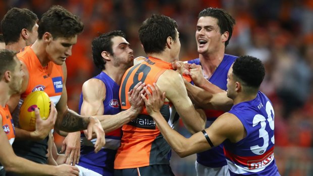 The Giants' Jeremy Cameron clashes with Tom Boyd of the Bulldogs during the first preliminary final last September.