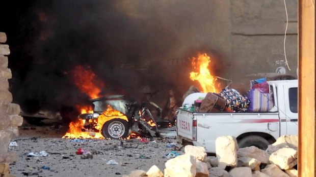 A car is engulfed by flames during clashes in the city of Ramadi.