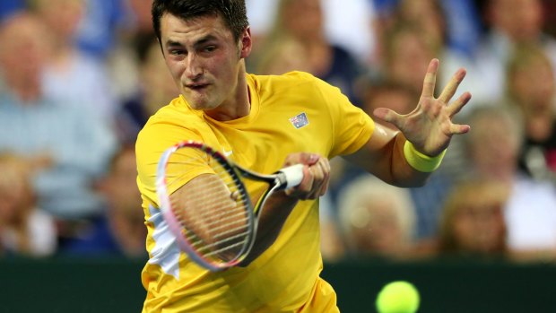 Under pressure: Bernard Tomic plays a forehand return to Britain's Andy Murray.