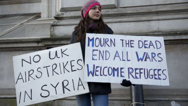 A peace protester holds placards outside Downing Street, London, on Tuesday. 