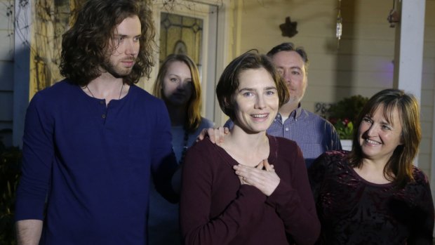 Absorbing the moment: Amanda Knox, centre, stands with her mother, Edda Mellas, right, and her fiance, Colin Sutherland, left, as she talks to the media outside Mellas' home.
