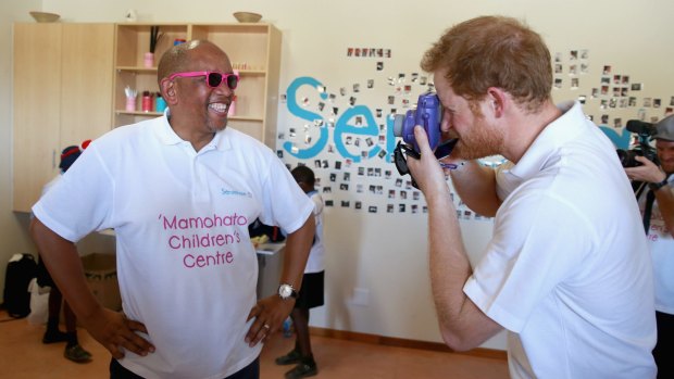 Prince Harry takes a photograph of Prince Seeiso at the new Mamohato Children's Centre in Maseru, Lesotho. 