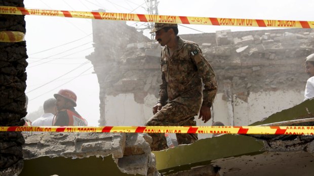 A soldier searches the rubble in Attock on Sunday.