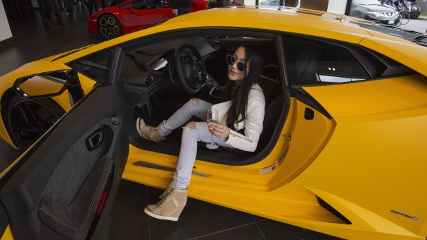 Chelsea Jiang sits in a car  at a Lamborghini dealership reception in Vancouver, British Columbia.