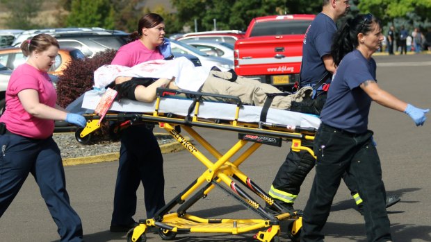Authorities carry a shooting victim away from the scene after a gunman opened fire at Umpqua Community College in Roseburg earlier this month.