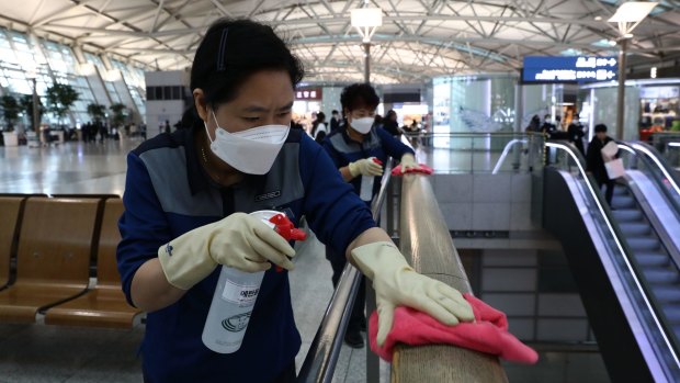 Disinfection workers spray anti-septic solution at Incheon airport.