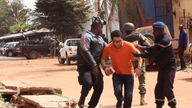 Mali security forces assist a hostage during Friday's attack.