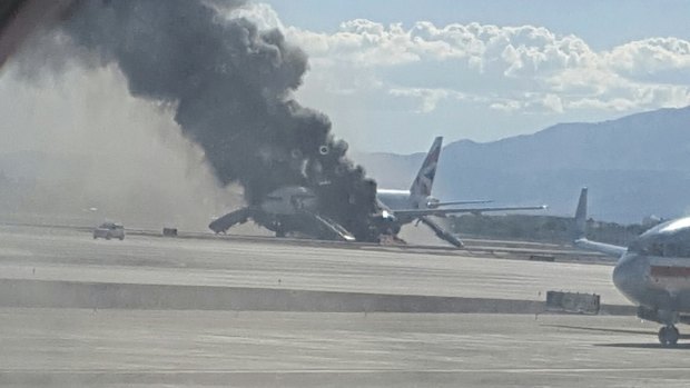 In this photograph taken through a plane window, smoke billows from the British Airways jet at McCarren International Airport, Las Vegas. An engine on the British Airways plane caught fire on take-off, forcing passengers to escape on emergency slides.