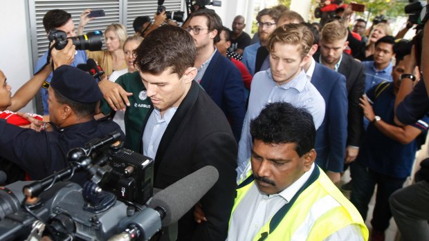 James Paver, centre left, Nick Kelly, centre with glasses, and Thomas Whitworth, centre right, of the nine Australian men arrested are escorted to the Sepang Magistrate in Sepang on Thursday.