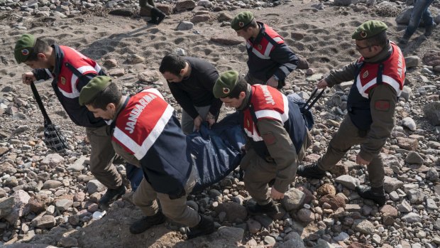 Turkish paramilitary police officers carry the dead body of a migrant from the beach near the Aegean town of Ayvacik, Canakkale, Turkey, on Saturday.