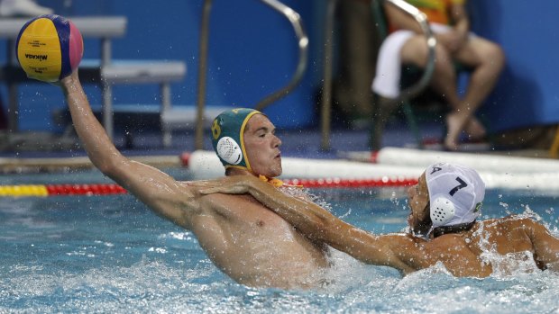 Australia's Aaron Younger, left, tries to pass the ball under pressure from Brazil's Gustavo Guimaraes, during a water polo preliminary round match in Ri on Saturday.