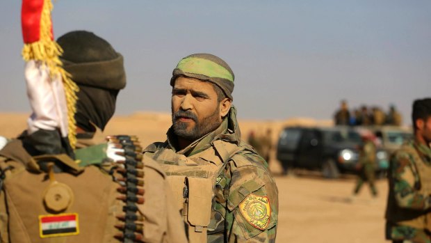 Fighters of the Popular Mobilisation Forces stand at the front line  outside Mosul this month.