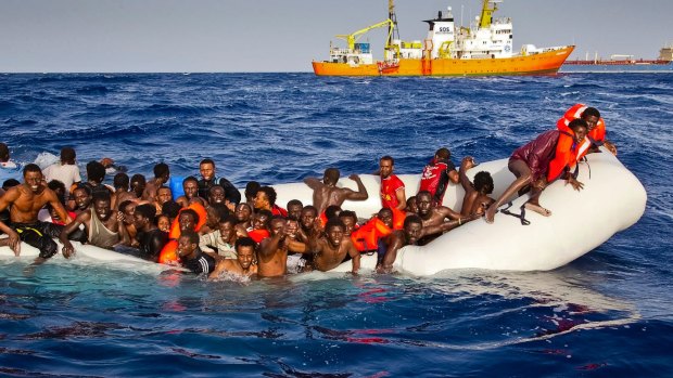 Migrants ask for help from a dinghy as they are approached by the SOS Mediterranee's ship Aquarius, background, off the coast of the Italian island of Lampedusa. in April.