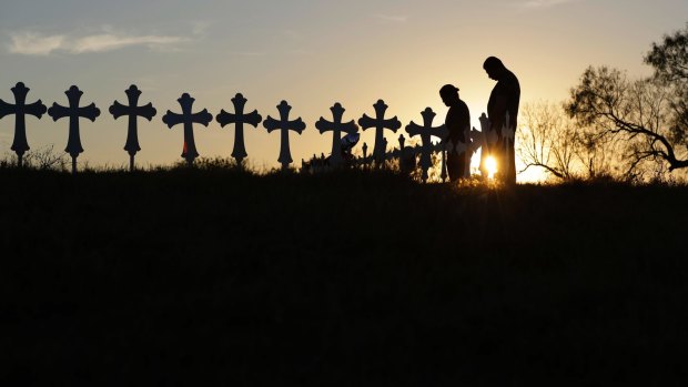 Kenneth and Irene Hernandez pay their respects as they visit a makeshift memorial with crosses placed near the scene of a shooting at the First Baptist Church of Sutherland Springs, Monday, Nov. 6, 2017, in Sutherland Springs, Texas. A man opened fire inside the church in the small South Texas community on Sunday, killing and wounding many. (AP Photo/Eric Gay)