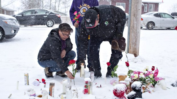 A family in La Loche, Saskatchewan, pay their respects to the victims of the school shooting.  