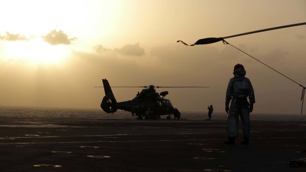 A French Navy Dolphin helicopter prepares to take off at sunset from the aircraft carrier Charles de Gaulle, which is operating in the Gulf.