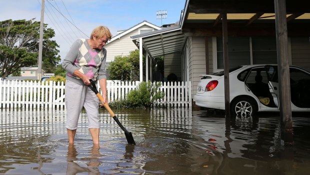 An Avoca Beach resident cleans up her property on the Central Coast after flooding on Wednesday.